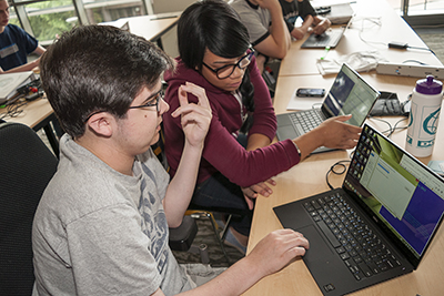Two students help each other on the computer. Two students help each other on the computer.
