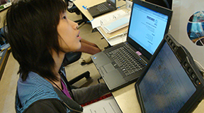 A woman uses a computer as well as assistive technology. A woman uses a computer as well as assistive technology.