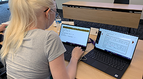 A student uses screen enlarging software and two laptops to work on a coding project. A student uses screen enlarging software and two laptops to work on a coding project.