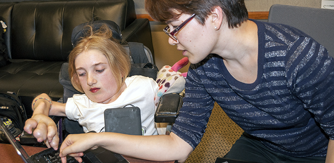 An instructor works with a student on a computing project An instructor works with a student on a computing project