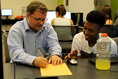 AccessCSForAll PI Andy Stefik shows a student how to code with a diagram on paper.
